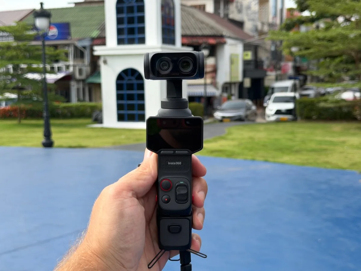 Insta360 Luna Ultra in der Hand auf einem Stadtplatz mit Laterne und Gebäuden