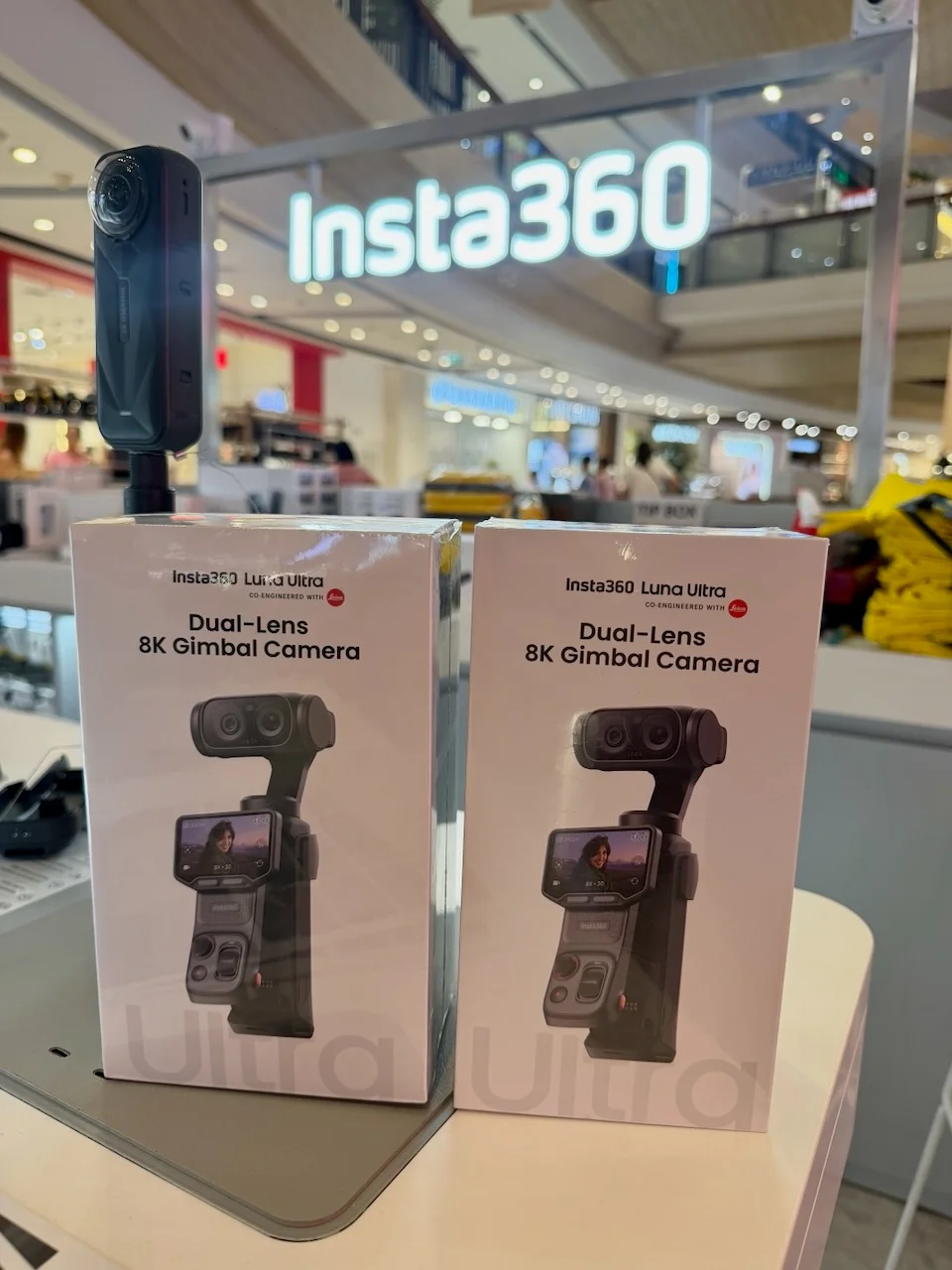 Zwei verpackte Insta360 Luna Ultra Kartons im offiziellen Insta360-Store in Bangkok, mit beleuchteter Insta360-Schriftzug im Hintergrund